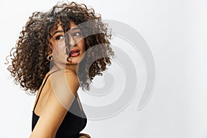 Beautiful woman with curly afro hair posing on a white isolated background smile happiness in jeans and black top