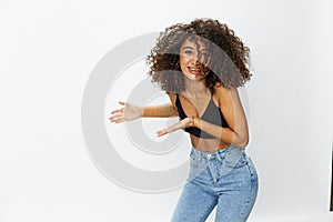 Beautiful woman with curly afro hair posing on a white isolated background smile happiness in jeans and black top