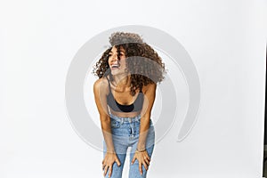 Beautiful woman with curly afro hair posing on a white isolated background smile happiness in jeans and black top