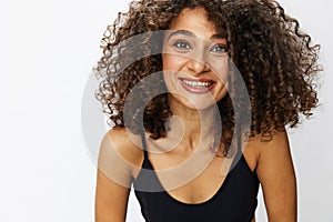 Beautiful woman with curly afro hair posing on a white isolated background smile happiness in jeans and black top