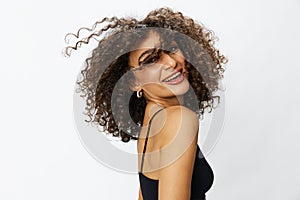 Beautiful woman with curly afro hair posing on a white isolated background smile happiness in jeans and black top