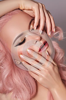 Beautiful Woman with Curly Colored Hairstyle and Fashion Make-up. Beauty Soft-Girl Style with Tender Pink Hair