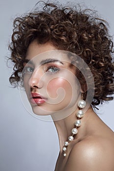 Beautiful woman with curly hair and fancy pearl earring