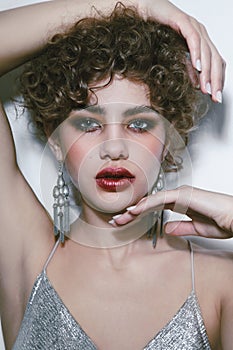 Beautiful woman with curly hair and smoky eye makeup