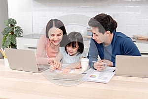 Beautiful woman And cute Asian girls drawing and writing on white paper The handsome man is working online. On the desk at home