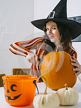 Beautiful woman cutting a pumpkin for Halloween