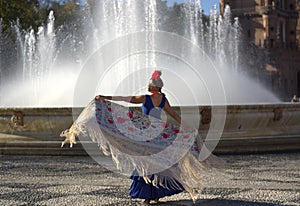 The beautiful woman dancing near the water of the fountain photo