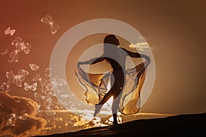 Beautiful woman dancing at sunset