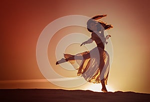Mujer hermosa bailar sobre el atardecer 