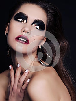 Beautiful woman with dark hair and extravagant black smokey eyes makeup