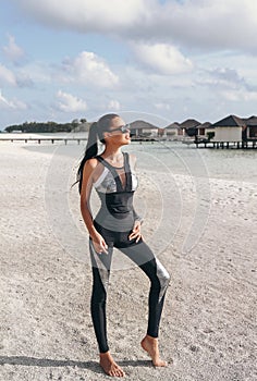 Beautiful woman with dark hair in sport suit relaxing on Maldive