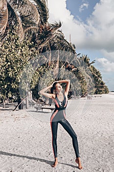 Beautiful woman with dark hair in sport suit relaxing on Maldive