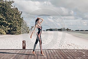 Beautiful woman with dark hair in sport suit relaxing on Maldive