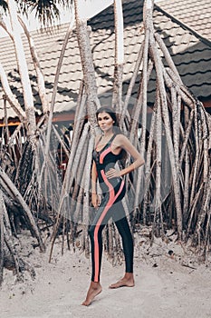 Beautiful woman with dark hair in sport suit relaxing on Maldive