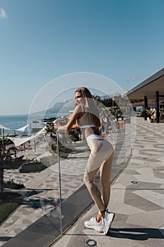 Beautiful woman with dark hair in sportive suit posing in terrace
