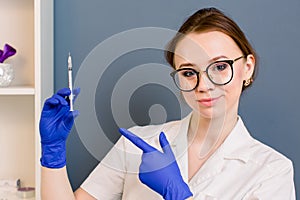 Beautiful woman doctor cosmetologist holding syringe for beauty injections. isolated female studio portrait.