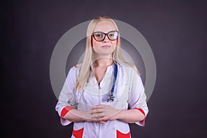 A beautiful woman doctor in a medical gown with glasses and a stethoscope around her neck