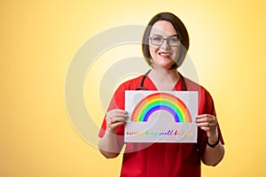 Beautiful woman doctor with stethoscope, wearing red scrubs holding a white paper