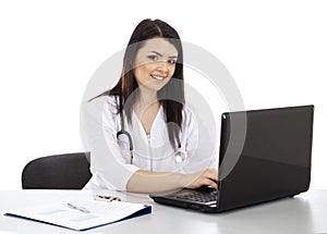 Beautiful woman doctor working on a laptop and smiling