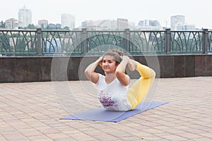 Beautiful woman doing Vriksasana pose on yoga class