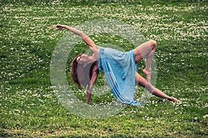 Beautiful woman doing yoga on meadow