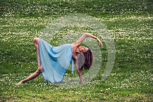 Beautiful woman doing yoga on meadow