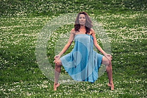 Beautiful woman doing yoga on meadow