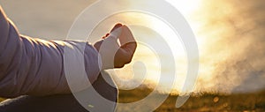 beautiful woman doing yoga by the sea at sunset - yoga, mindfulness, mental health background