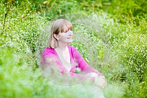 Beautiful woman dreaming in garden among flowers