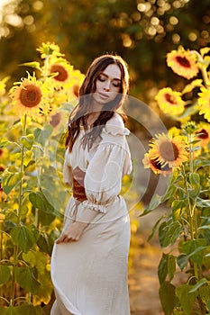 Beautiful woman in a dress in a field of sunflowers
