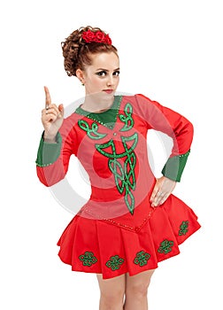 Beautiful woman in dress for Irish dance showing up by finger is