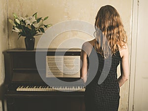 Beautiful woman in dress by piano