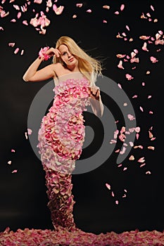 Beautiful woman in dress of rose petals