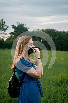 Beautiful woman in dress taking mask off, on fresh air
