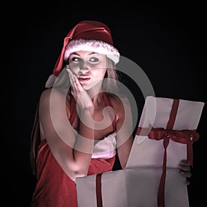 Beautiful woman dressed as Santa Claus, opening the box with hi