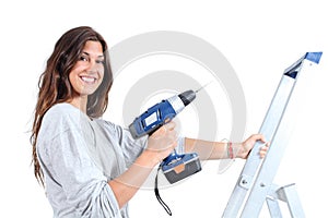 Beautiful woman with a drill on a ladder