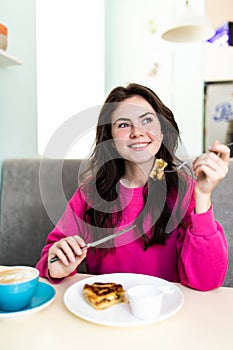 Beautiful woman drink coffee eating chocolate cake at cafe