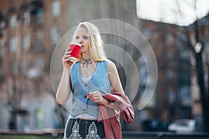 Beautiful woman drinking coffee in city street