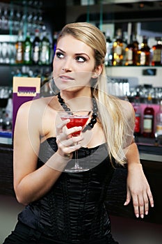 Beautiful woman drinking a martini at the bar