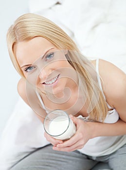 Beautiful woman drinking milk in bed