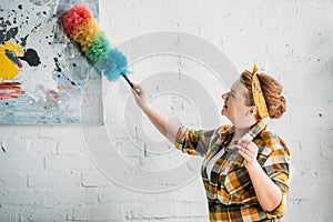 beautiful woman dusting paint on wall