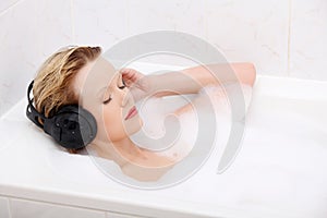 Beautiful woman with earphones in the bath.