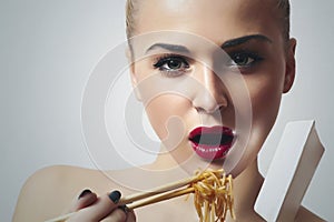 Beautiful woman eating chinese food. wok. close-up. red lips