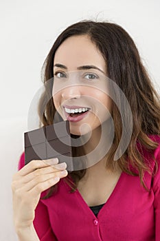 Beautiful woman eating a dark chocolate bar