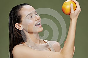 beautiful woman eating grapefruit in hands smile vitamins diet green background