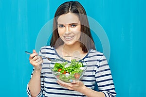Beautiful woman eating healthy food green salad.