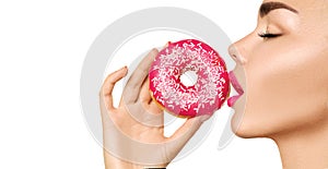 Beautiful woman eating pink donut