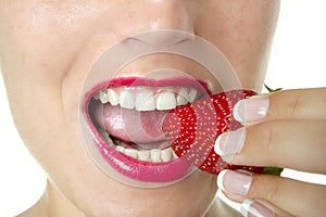 Beautiful woman eating a red strawberry