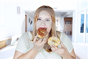 Beautiful woman eats two donuts