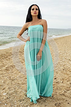 beautiful woman in elegant dress posing at beach